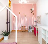 Kinderzimmer in einer 3-Zimmer-Wohnung mit rosa Wand und Holzboden.
