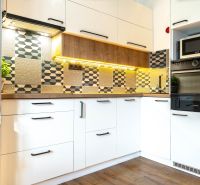 Moderne Küche mit geometrischen Fliesen und Holzboden in einer 3-Zimmer-Wohnung.