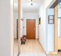 Eingangsflur in einer 3-Zimmer-Wohnung mit Holzboden und Garderoben.