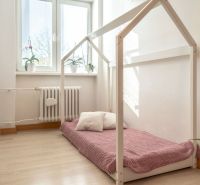 Kinderzimmer mit einer Matratze auf dem Boden mit Holzelementen in einer 3-Zimmer-Wohnung.