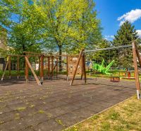 Ein Kinderspielplatz umgeben von Bäumen in der Krivá-Straße in Košice, Stadtteil Juh.