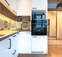 Küche in einer 3-Zimmer-Wohnung mit gemusterten Fliesen und einem Boden mit Holzdekor.