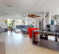 Wohnzimmer mit Ecksofa, offenem Raum und Wendeltreppe in einem Einfamilienhaus.