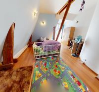 Kinderzimmer in einem Einfamilienhaus mit Holzboden und buntem Teppich.
