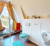 Badezimmer in einem Einfamilienhaus mit Waschbecken, hängendem WC und Aussicht durch ein großes Fenster.