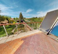 Die Terrasse des Einfamilienhauses in Veľké Chlievany mit Blick auf den Garten und die Solarpaneele.