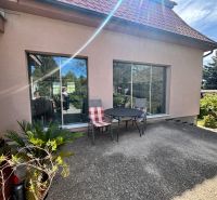 Die Terrasse des Einfamilienhauses in Veľké Chlievany mit Tisch, Stühlen und Pflanzen.
