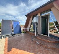 Ein Einfamilienhaus in Veľké Chlievany mit einer geräumigen Terrasse und Solarpanelen.