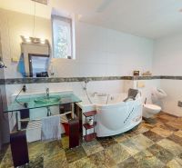 Badezimmer im Einfamilienhaus mit Badewanne, Dusche und Waschmaschine.