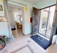 Eingangshalle mit offenen Türen, Bildern und einer Pflanze im Einfamilienhaus.
