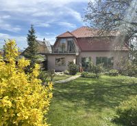 Garten und Einfamilienhaus in Veľké Chlievany mit Balkon und Bäumen.
