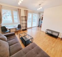 Helles Wohnzimmer mit Sofa, Tisch und Holzboden in einer 3-Zimmer-Wohnung.