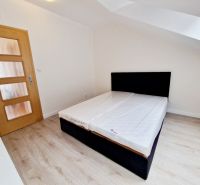 Schlafzimmer in einer 3-Zimmer-Wohnung mit Holzboden und einfachem Bett.