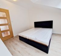 Schlafzimmer mit Holzboden in einer 3-Zimmer-Wohnung, einfaches Bett.