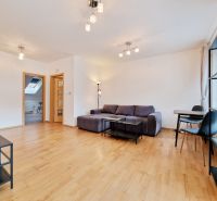 Wohnzimmer mit Holzboden, Sitzgarnitur und Esstisch in einer 3-Zimmer-Wohnung.
