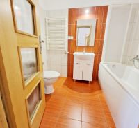 Badezimmer in einer 3-Zimmer-Wohnung mit Badewanne, Waschbecken und orangefarbenen Fliesen.