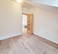 Ein Zimmer in einer 3-Zimmer-Wohnung mit einem Boden in Holzoptik und hellen Wänden.
