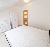 Schlafzimmer mit Bett, Kleiderschrank und Holzboden in einer 3-Zimmer-Wohnung.