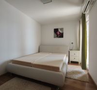 Helles Schlafzimmer in einem Einfamilienhaus mit Bett und Holzboden.