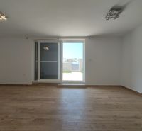Ein Zimmer mit einem Holzboden und Balkontüren in einem Einfamilienhaus.