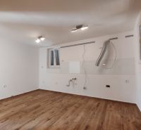 Eine leere Küche in einem Einfamilienhaus mit einem Holzboden.