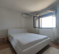 Schlafzimmer in einem Einfamilienhaus mit großem Fenster und Bett, Boden mit Holzdekor.