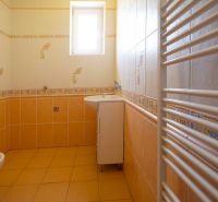 Ein Badezimmer in einem Einfamilienhaus mit gelben Wänden und einem weißen Heizkörper.