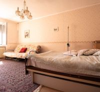 Schlafzimmer in einem Einfamilienhaus mit Teppich, Bett, Sofa und Kronleuchter.