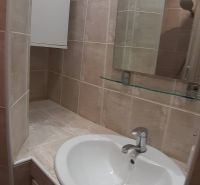Kleines Badezimmer mit Waschbecken und Spiegel in einer Zweizimmerwohnung.