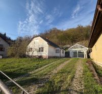 Ein Einfamilienhaus in Štós, umgeben von Grün und einer Holzkonstruktion eines Unterstands.