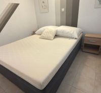 Schlafzimmer in einem Einfamilienhaus mit einem einfachen Bett und Nachttischen.