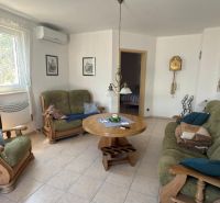 Wohnzimmer in einem Einfamilienhaus mit Sofa und Holzmöbeln.