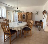 Küche in einem Einfamilienhaus mit rundem Tisch, Holzstühlen und Kredenz.