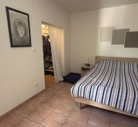 Schlafzimmer mit Keramikfliesen, Wandzeichnung und Bett in einem Einfamilienhaus.