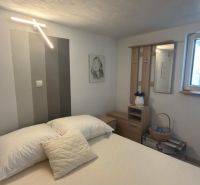 Schlafzimmer im Einfamilienhaus mit dekorativer Beleuchtung und Bildern an den Wänden.