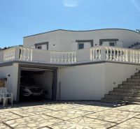 Ein Einfamilienhaus in Vinjerac mit weißer Fassade, Steindielen und Geländer.