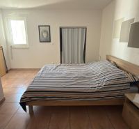 Schlafzimmer in einem Einfamilienhaus mit Bett, Keramikboden und minimalistischem Dekor.
