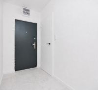 Eingangsflur mit grauen Türen und weißen Wänden in einer 3-Zimmer-Wohnung.