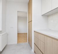 Küche mit Schränken und Blick auf den Boden mit Holzdekor in einer 3-Zimmer-Wohnung.