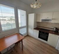 Küche in einer Einzimmerwohnung mit Holzboden und Esstisch.