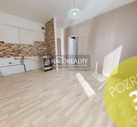 Ein Zimmer mit Holzboden und einer Kochnische in einer Einzimmerwohnung.