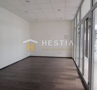 Ein geräumiger Raum mit Glastüren und dunklem Boden in einer 2-Zimmer-Wohnung.
