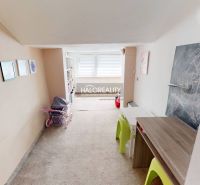 Kinderzimmer in einem Einfamilienhaus mit Teppich, Möbeln und Kinderzeichnungen.