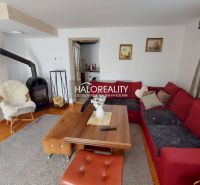 Wohnzimmer in einem Einfamilienhaus mit Kamin, bequemer Couch und Holztisch.