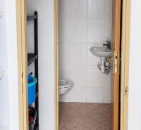 Badezimmer in Geschäftsräumen mit Toilette und Waschbecken, einfaches Fliesendesign.