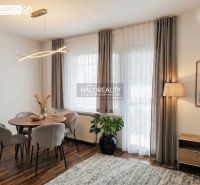 Einzimmerwohnung mit Esstisch, Stühlen und Holzboden, gedämpfte Beleuchtung.