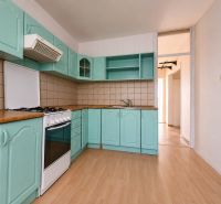 Eine Küche mit türkisfarbenen Schränken und einem Holzboden in einer 4-Zimmer-Wohnung.