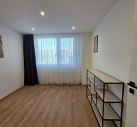 Ein Zimmer mit einem Holzboden und einem Regal in einer 3-Zimmer-Wohnung.