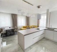 Küche in einer 3-Zimmer-Wohnung mit gelbem Sofa und Esstisch.