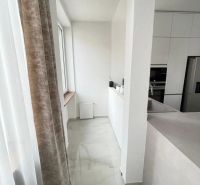 Küche in einer 3-Zimmer-Wohnung mit weißen Schränken und Marmorboden.
